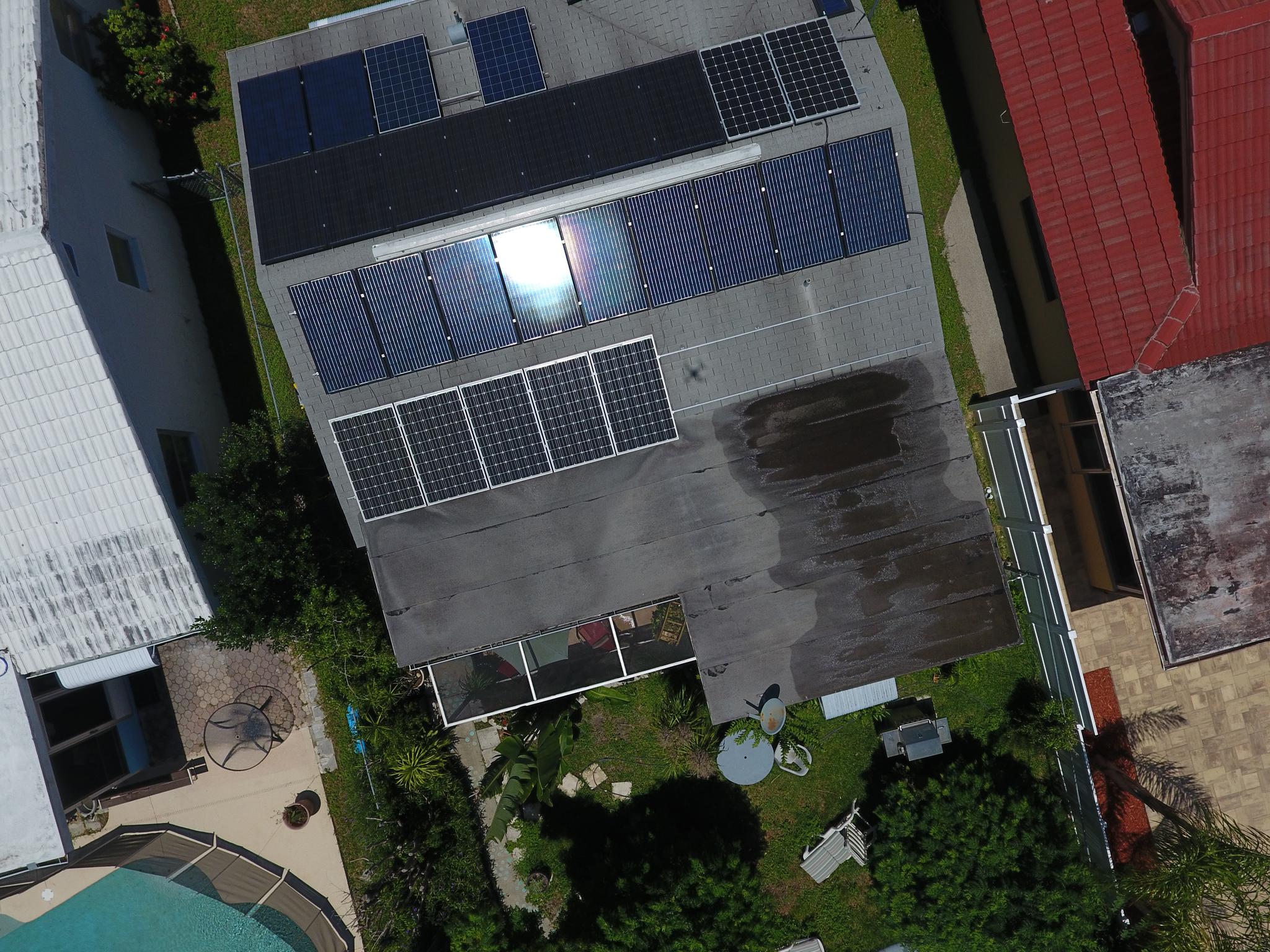 Aerial View of our Shop showing All the Differnt Solar Panels we Used as we Slowly Grew our System to Stay at a Zero Electric Bill Despite Installing a Free Car Charger for Anyone to Use