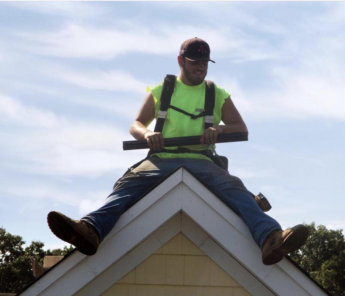 Our Solar Installer, Matt, sitting on top of a dormer on a house